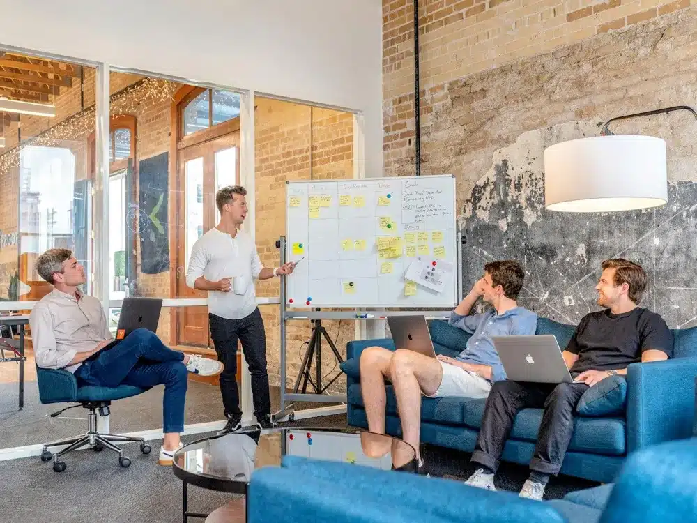 Équipe réunie devant un tableau blanc pour préparer une comparaison